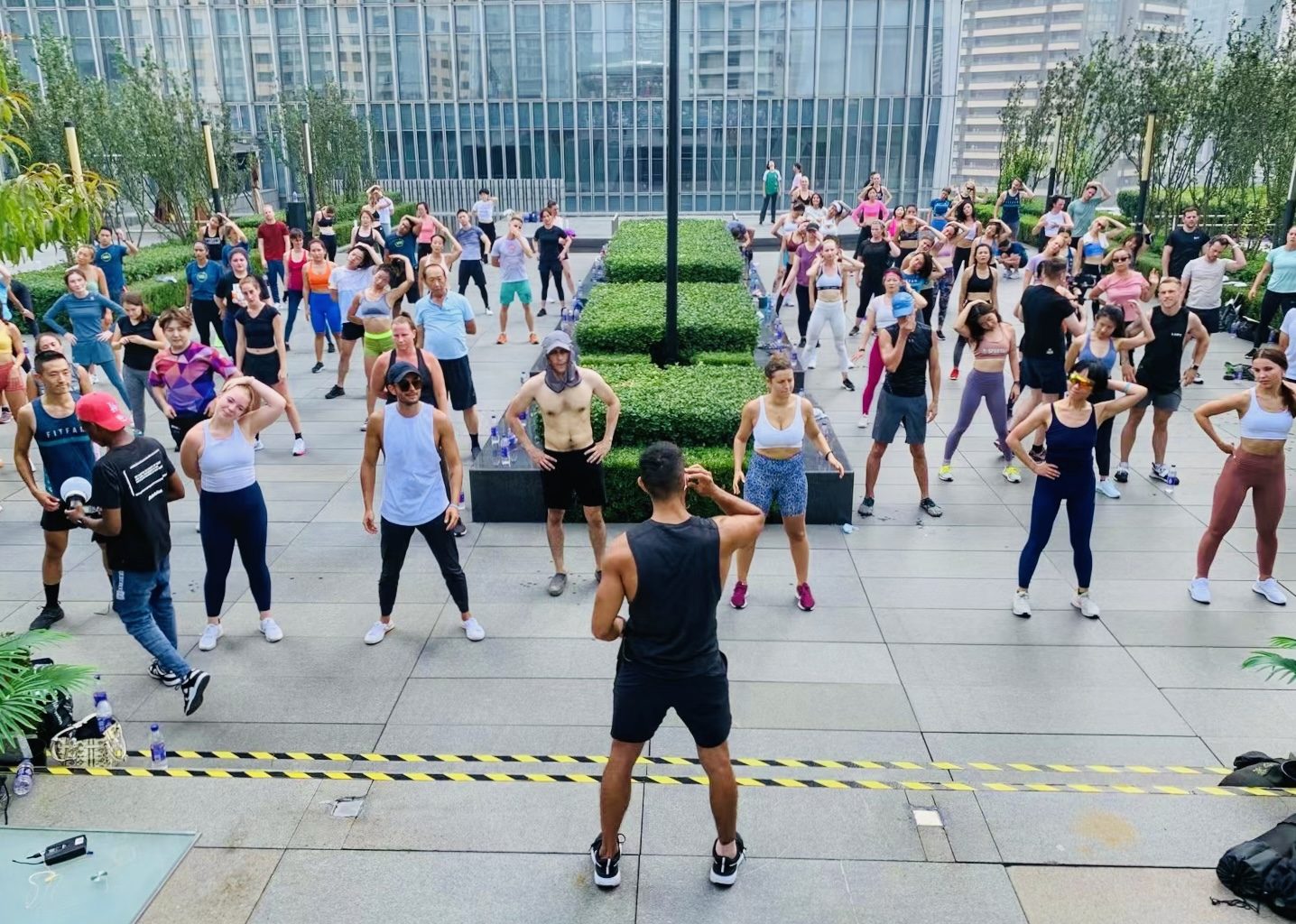 Angelo leading an outdoor group workout on a rooftop terrace